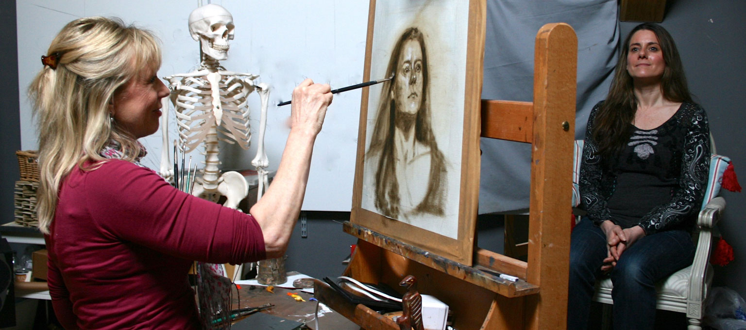 Lindy painting an oil portrait in her studio with the sitter